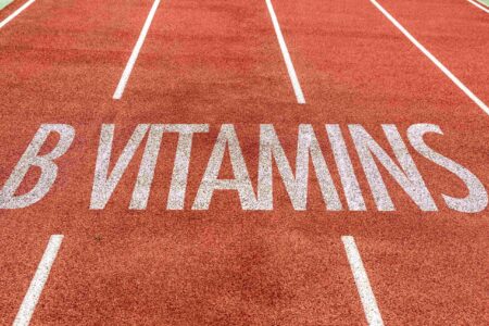 The image shows a section of a running track with the words 'B VITAMINS' painted in large white letters across the lanes