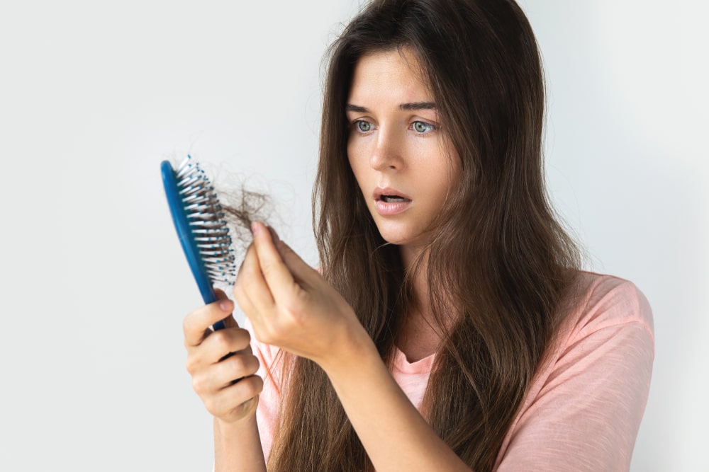 image of womans Hair Falling out due to biotin deficiency